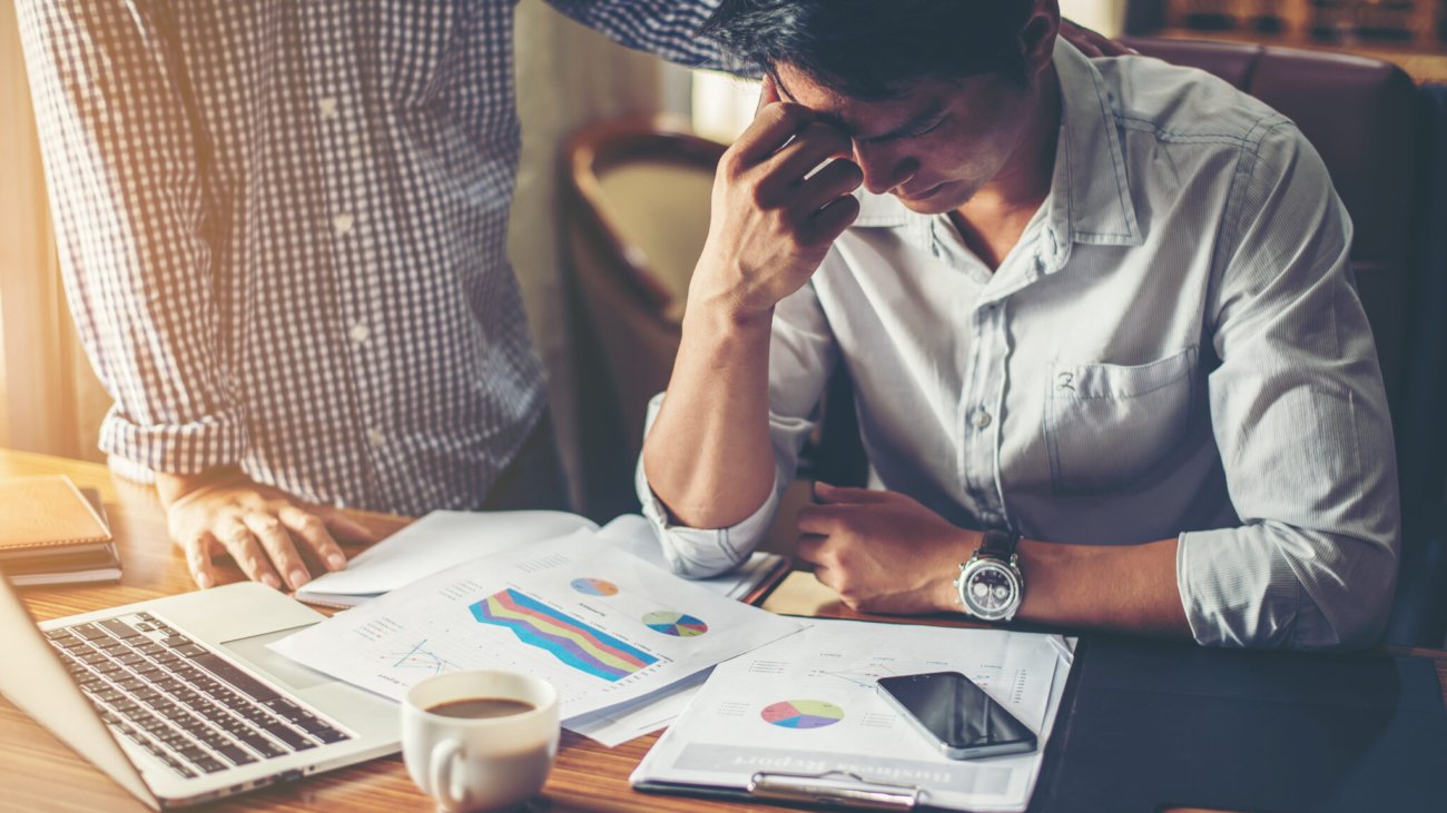 Serious young businessman looking at financial report seem like something mistake with his boss in office.