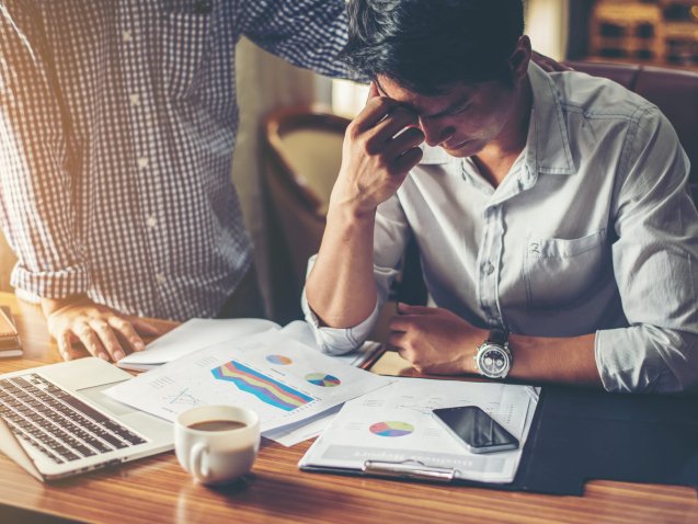 Serious young businessman looking at financial report seem like something mistake with his boss in office.