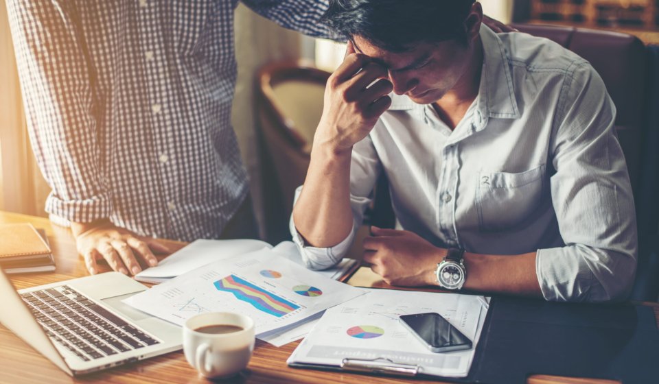 Serious young businessman looking at financial report seem like something mistake with his boss in office.
