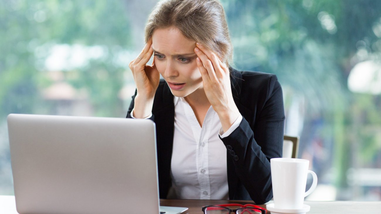 Persona preocupada revisando sus deudas frente al computador