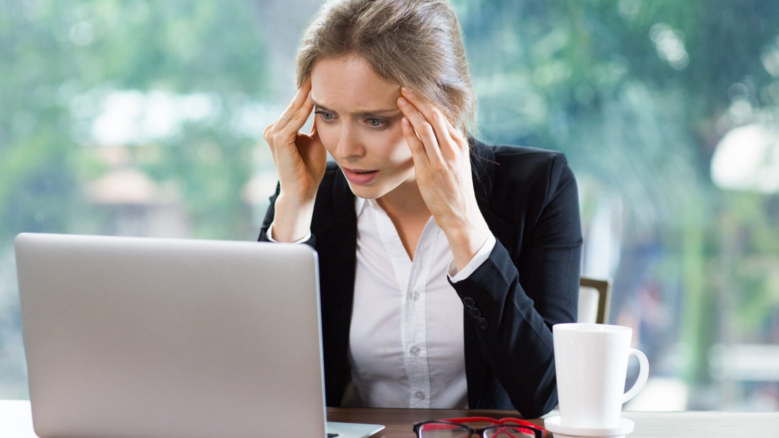 Persona preocupada revisando sus deudas frente al computador
