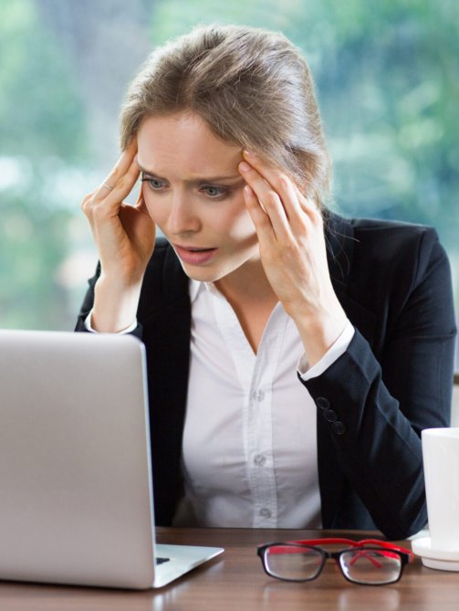 Persona preocupada revisando sus deudas frente al computador