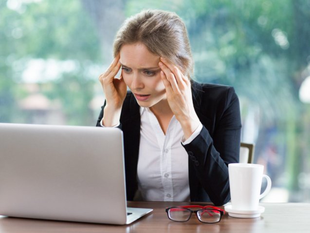 Persona preocupada revisando sus deudas frente al computador