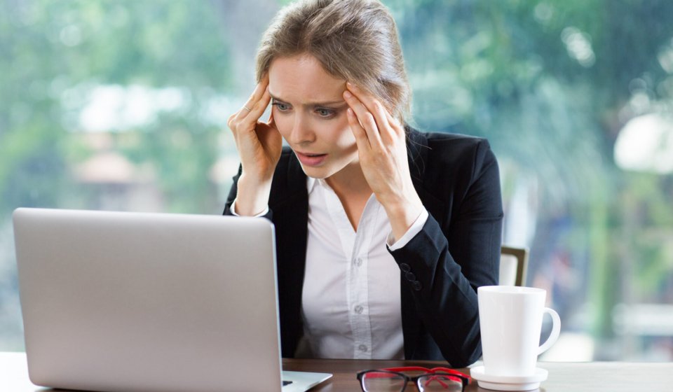 Persona preocupada revisando sus deudas frente al computador